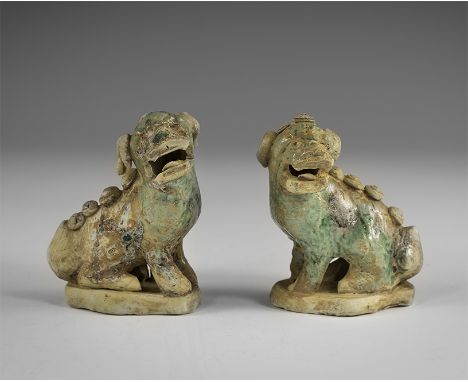 Kangxi Period, Late 17th century AD. An opposed pair of green-glazed ceramic figurines of crouching lions each with the head 