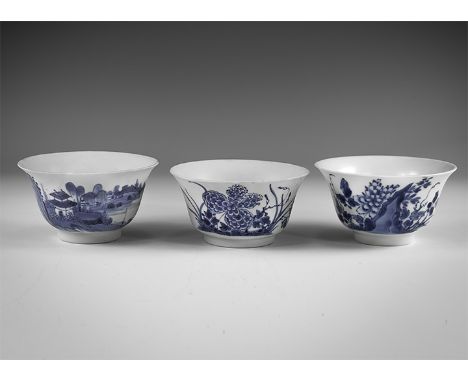 Kangxi Period, Late 17th century AD. A group of three blue and white glazed ceramic tea bowls, one with river landscape and h