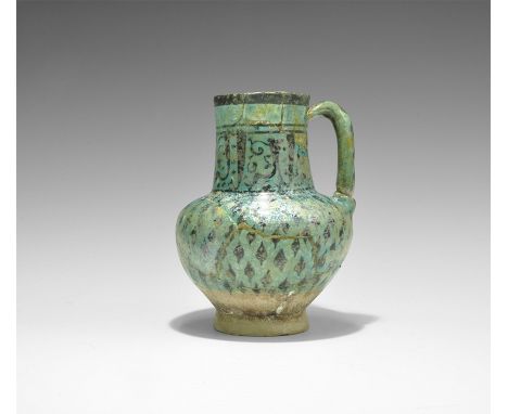 11th-12th century AD. A ceramic jug with piriform body, tubular neck and strap handle; iridescent turquoise glaze with band o