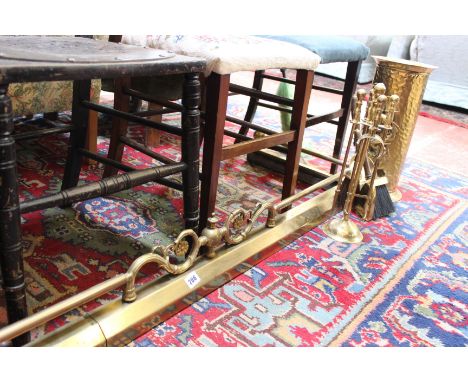 A brass fender, together with a brass bucket and fire tools 