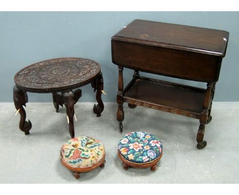 Hardwood carved oval occasional table on elephant supports, oak trolley and two tapestry topped stools