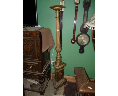 A gesso and giltwood Torchere having a turned and reeded pillar blending with a carved foliage to a triangular plinth, the th