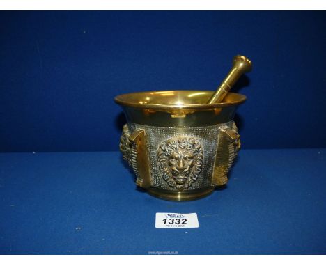 A Brass pestle and Mortar with lion masks and ridged pillars detail, 5 1/2" diameter.