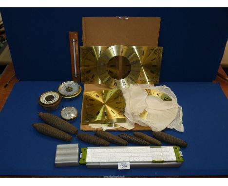 A quantity of new clock faces in cardboard folder, a tray of seven various weights for cuckoo clocks, three barometer movemen