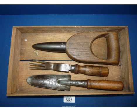 A box containing an old trowel with measurements, a small old garden hand weeder and old dibber with iron end.