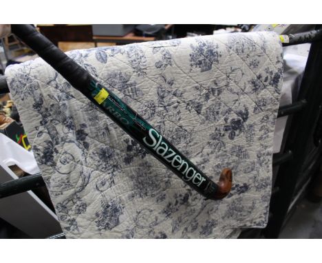 Quilted bed cover and Slazenger hockey stick