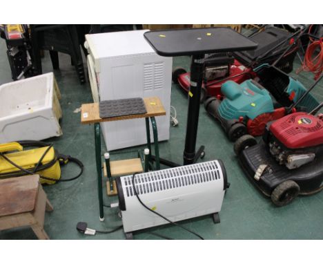 A green metal folding step stool, a black media stand and an electric heater 