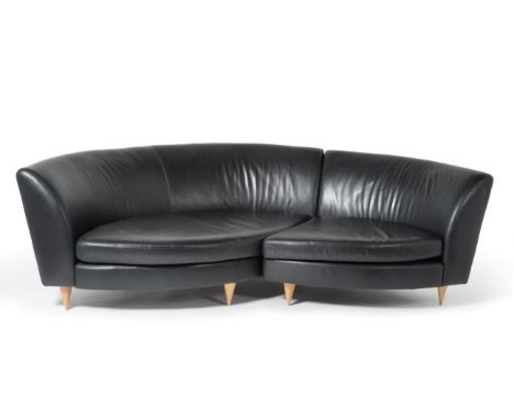 A Black Leather Content Corner Sofa, by Conran, in two sections with curved back support, two squab cushions and raised on be