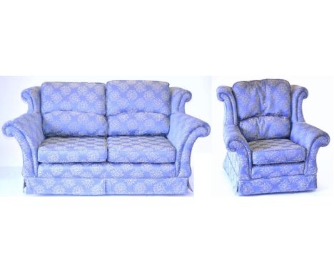 A Three-Seater Sofa, upholstered in blue and yellow floral fabric with squab cushions and rounded arm supports, 265cm by 92cm