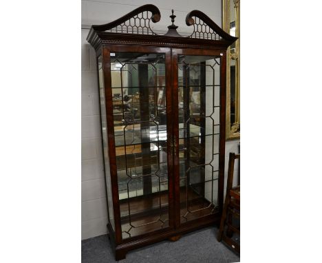 A Reproduction Mahogany Display Cabinet, in Chippendale style with fret carved scrolled pediment above astragal glazed doors 