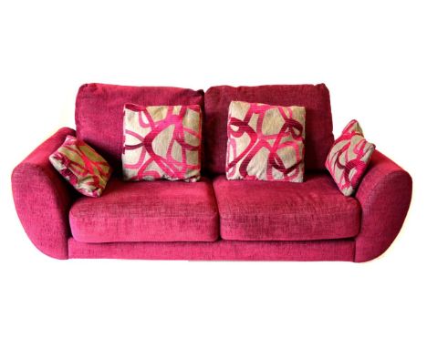 A DFS Amanda Model Three-Seater Sofa, upholstered in pink fabric with grey and pink scatter cushions, with rounded arms, and 