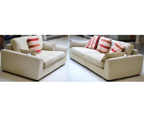 A Pair of Cream Upholstered Sofas, of recent date, comprising a three-seater sofa with squab cushions, raised on square form 