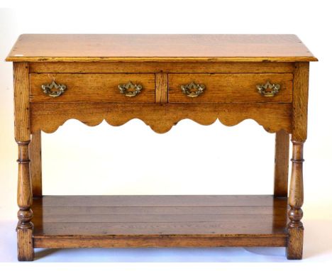 A Reproduction Oak Two Drawer Hall Table, with two frieze drawers above a wavy shaped apron, raised on baluster turned forele