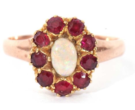 Opal and garnet cluster ring centring an oval cabochon opal raised within a small garnet surround (unmarked), size O (a/f)