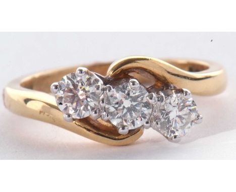 18ct gold three stone diamond ring featuring three round brilliant cut diamonds between plain polished cross over shoulders, 