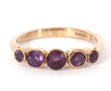 Modern 9ct gold amethyst five stone ring featuring five graduated round cut amethysts, all bezel set, size K