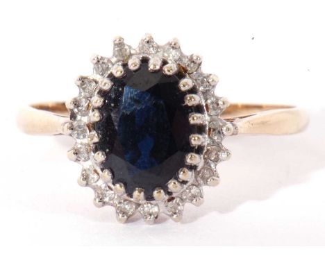 9ct gold sapphire and diamond cluster ring, the oval faceted dark sapphire multi-claw set within a small single cut diamond s