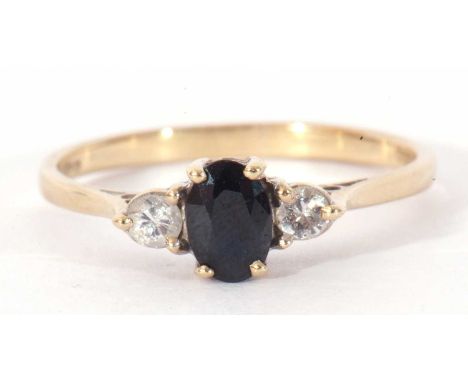 9ct gold sapphire and diamond three stone ring centring a small oval cut sapphire flanked by two small diamonds, size N/O