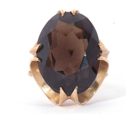 9ct gold and quartz dress ring, the oval faceted quartz 20 x 8mm, cardinal set in a basket mount, London 1971, size K