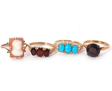 Four 9ct gold rings to include a cameo ring, a three stone garnet ring, a three stone turquoise coloured stone ring, together