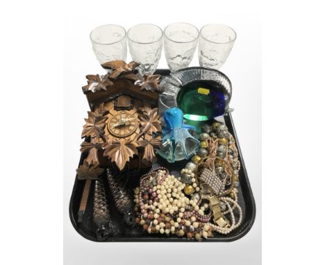 A reproduction carved cuckoo clock, a group of costume bead necklaces, glass octopus and fish paperweights, and a set of four