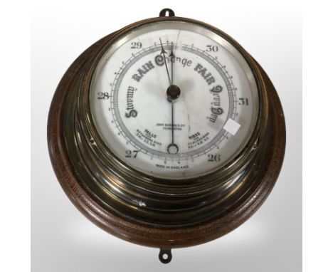 A circular oak and brass ship's barometer, diameter 27 cm
