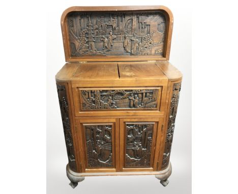 A 20th century oriental heavily carved camphor wood drinks cabinet, 85cm x 40cm x 99cm. 