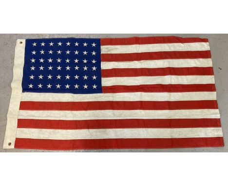 A WWII style US army "Stars &amp; Stripes" flag with 48 stars. With brass eyelets and printed markings to include date. Each 