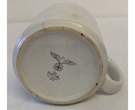 A WWII style German ceramic mug with printed details to base. Some damage to glaze on one side. Approx. 9cm tall x 9cm diamet