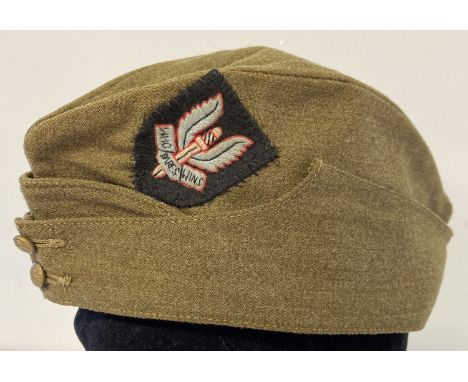 A WWII style British army side cap with hand embroidered S.A.S cap badge sewn on it.  