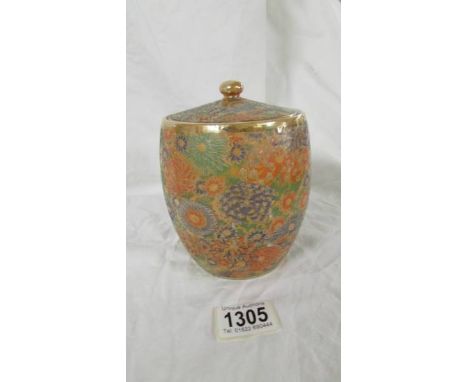 A 6" high Japanese ceramic biscuit jar with lid.&nbsp; Lovely heavily patterned body with intricate floral pattern on an oran