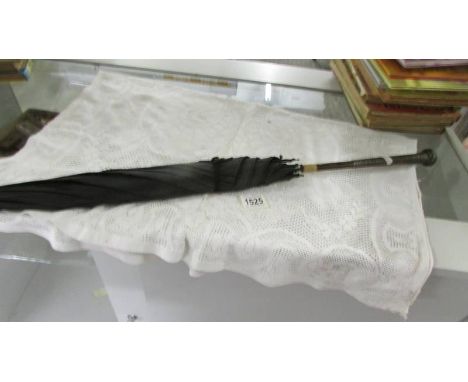 A vintage umbrella with silver handle.