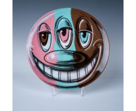 Fine bone china plate designed with a cartoon-like smiling face with three eyes, in a teal, brown, and pink coloration. Part 