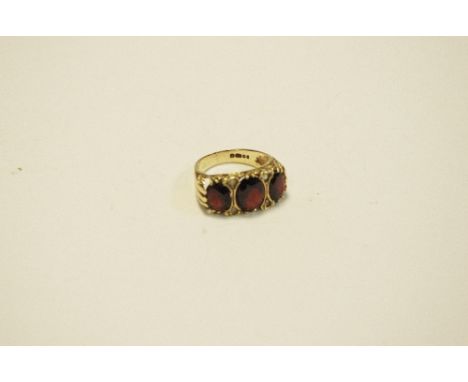 A 9ct gold and garnet three stone ring (4g)