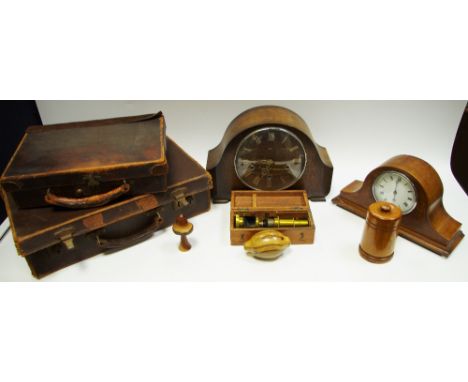 A Sheraton Revival walnut mantel clock, typically inlaid; two small leather suitcases; clocks