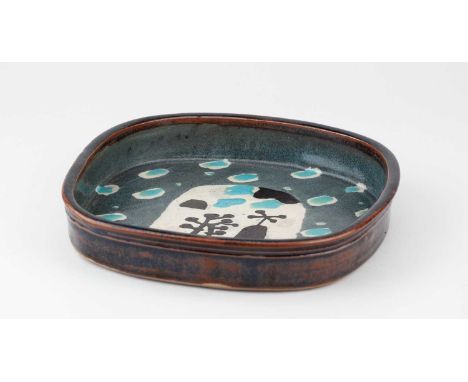 † JOHN MALTBY (1936-2020); a square stoneware dish decorated with a stylised building and trees, inscribed signature, 24 x 24