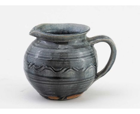 † KATHARINE PLEYDELL-BOUVERIE (1895-1985); a stoneware jug covered in blue/grey ash glaze with incised meander decoration, im