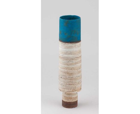 † ROBIN WELCH (1936-2019); a tall cylindrical stoneware vessel on a drum base covered in cream glaze with blue top and linear