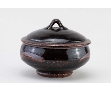 † PHIL ROGERS (1951-2020); a stoneware pot and cover covered in tenmoku breaking to kaki glaze with wax resist decoration, im