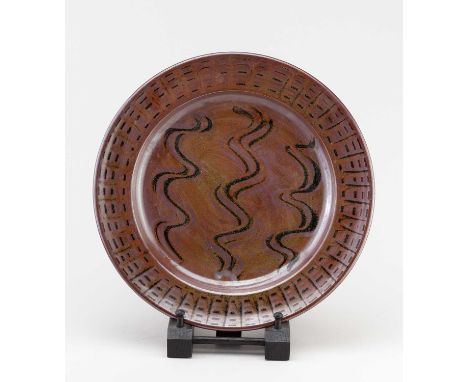 † RAY FINCH (1914-2012) for Winchcombe Pottery; a stoneware charger covered in kaki glaze with meander decoration, impressed 