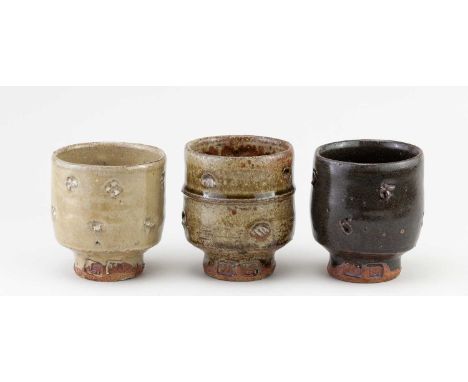 JIM MALONE (born 1946); a trio of stoneware yunomi covered in different glazes, impressed JM and L (for Lessonhall) marks, ta