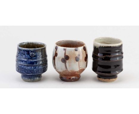 † PHIL ROGERS (1951-2020); a trio of stoneware yunomi covered in different glazes, impressed PR marks, tallest 10.5cm (3).Con