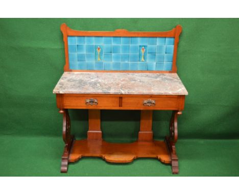 Mahogany washstand having raised blue tile back over a marble top and two short drawers with brass handles, standing on lyre 