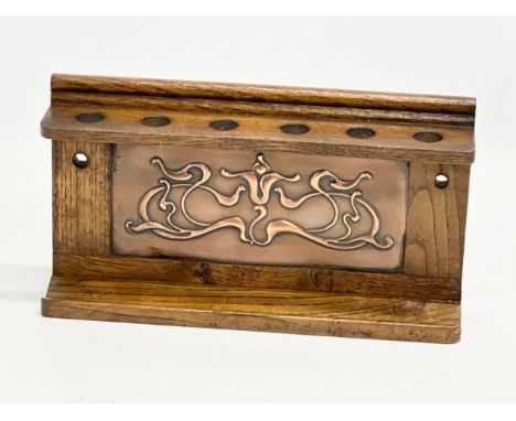 Liberty &amp; Co. An Early 20th Century Art Nouveau wall mounted pipe rack with copper panel. From Liberty &amp; Co. 25.5x5x1