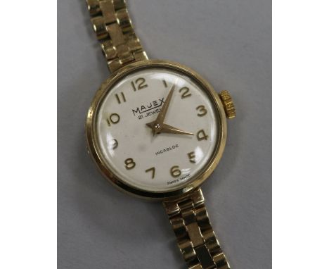 A lady's 9ct gold Majex manual wind wrist watch on a 9ct gold bracelet.