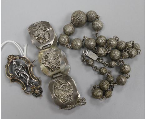 An early 20th century French silver and 18ct gold figural brooch with scrolling border, a Chinese white metal bracelet and a 