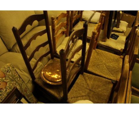 A pair of oak ladder back and rush seated dining chairs