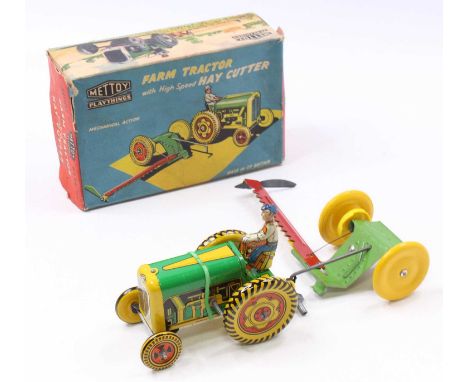 A Mettoy No.6435 tinplate and clockwork mechanical farm tractor, comprising green, red and yellow tin-printed body, with orig