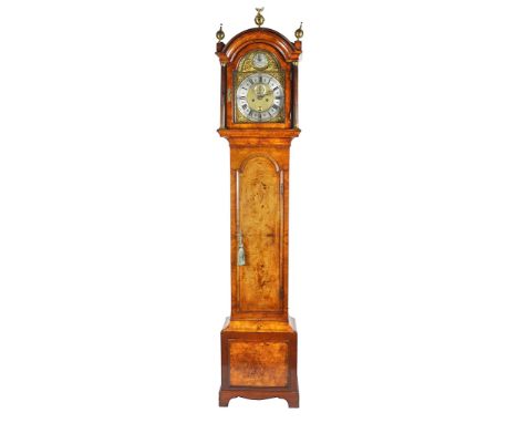 An early 19th century walnut long case clock. Brass dial with angel and serpent spandrels with silver chapter ring enclosing 