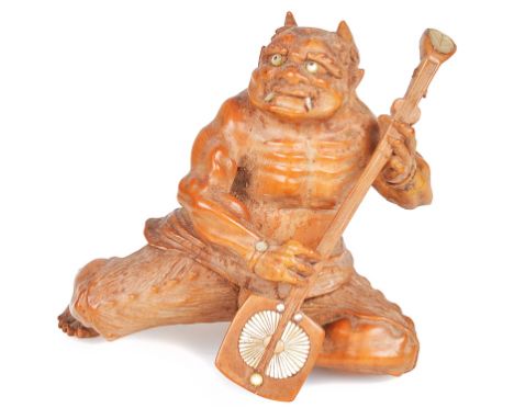 A Japanese boxwood OkimonoMeiji periodIn the shape of an Oni playing a Shamisen. With Mother-of-Pearl inlays.H 9 cm   CONDITI